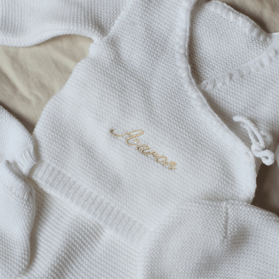 Détail de la broderie du prénom sur la tenue de naissance
