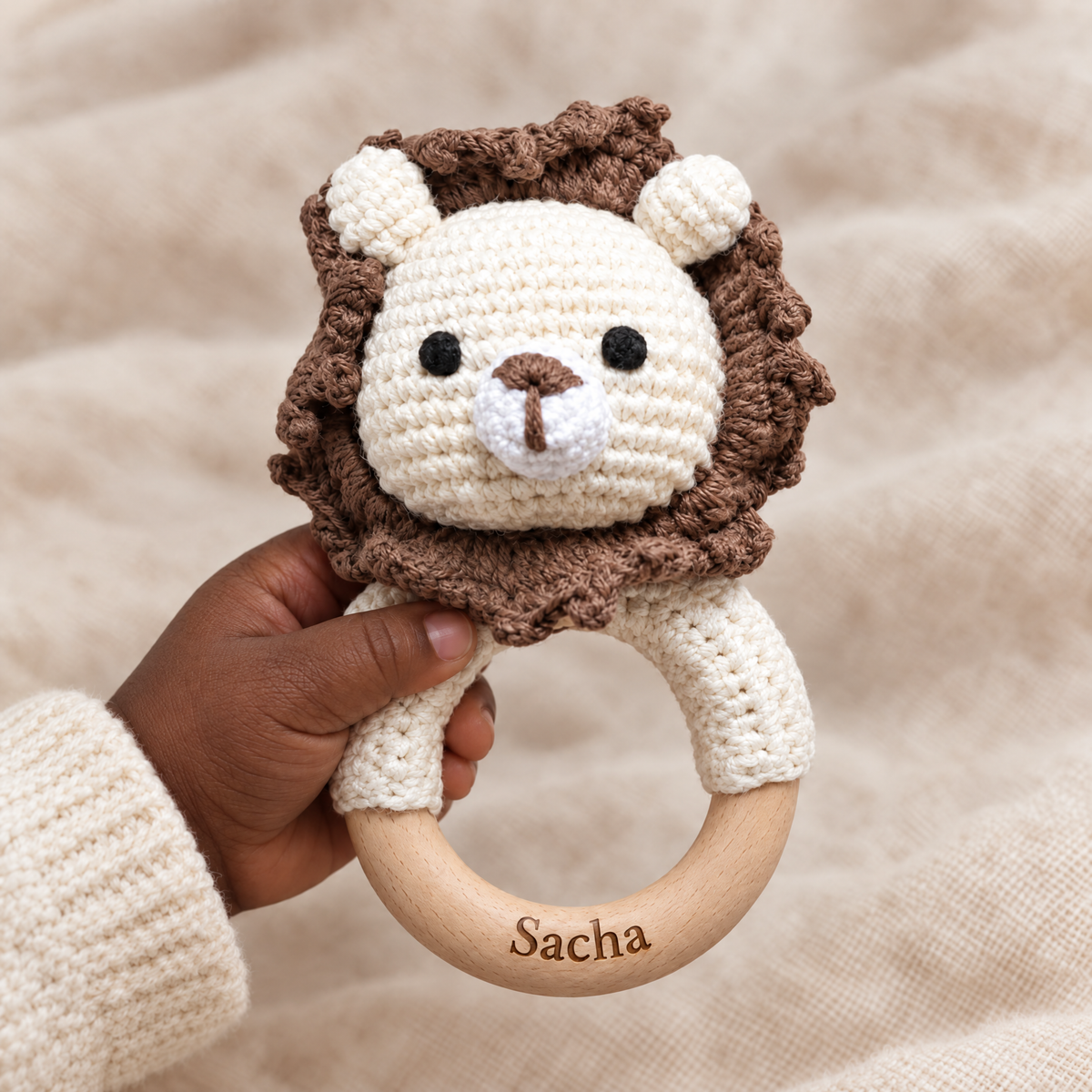 Hochet en crochet personnalisé lion brun tenu par bébé, prénom gravé