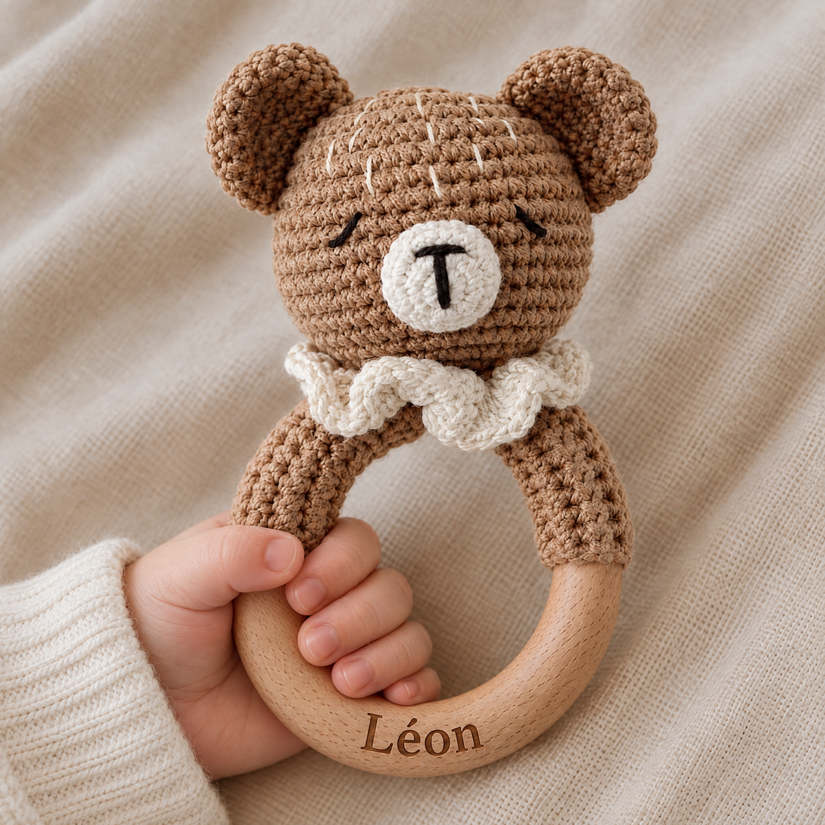 Hochet en crochet personnalisé ourson collerette tenu par bébé, prénom gravé