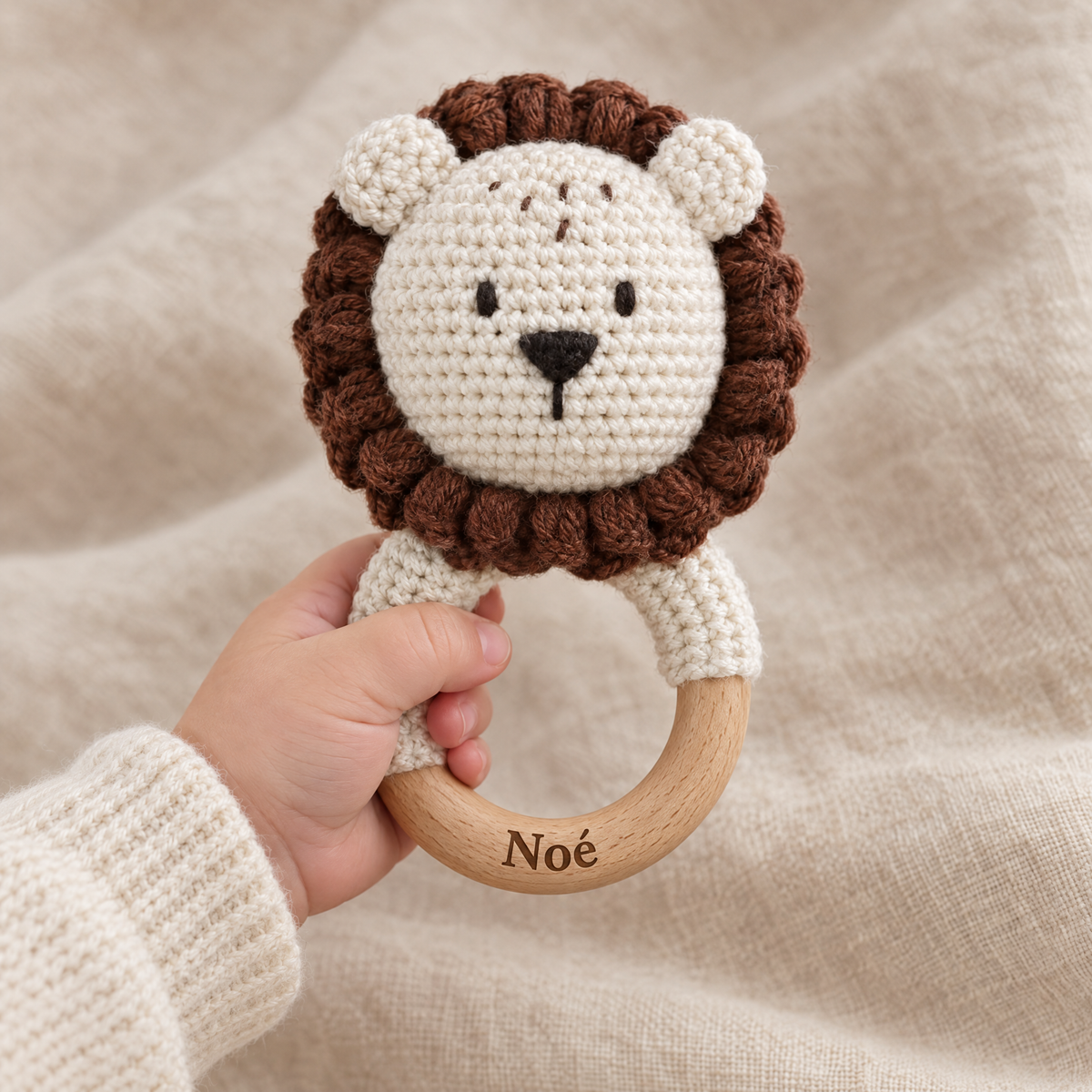 Hochet en crochet personnalisé lion brun tenu par bébé, prénom gravé