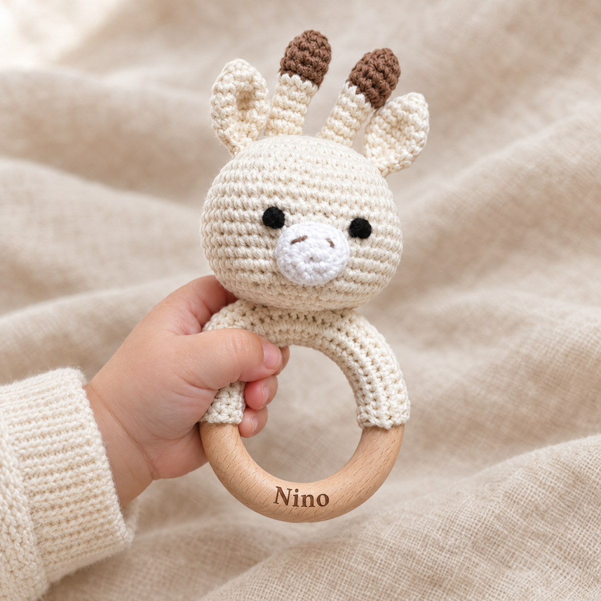 Hochet en crochet personnalisé girafe tenu par bébé, prénom gravé