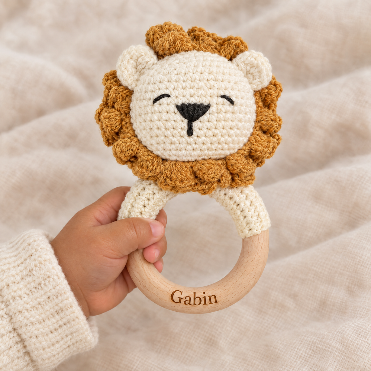 Hochet en crochet personnalisé lion roux tenu par bébé, prénom gravé