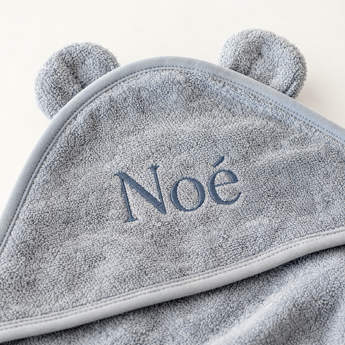 Capuche de la cape de bain ourson bleue avec le prénom Noé brodé